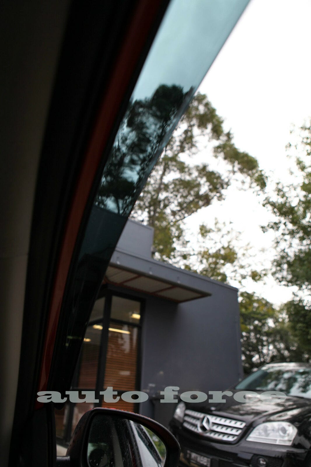Interior view through tinted HIC visor showing black Mercedes ML and silver BMW X3 parked outside