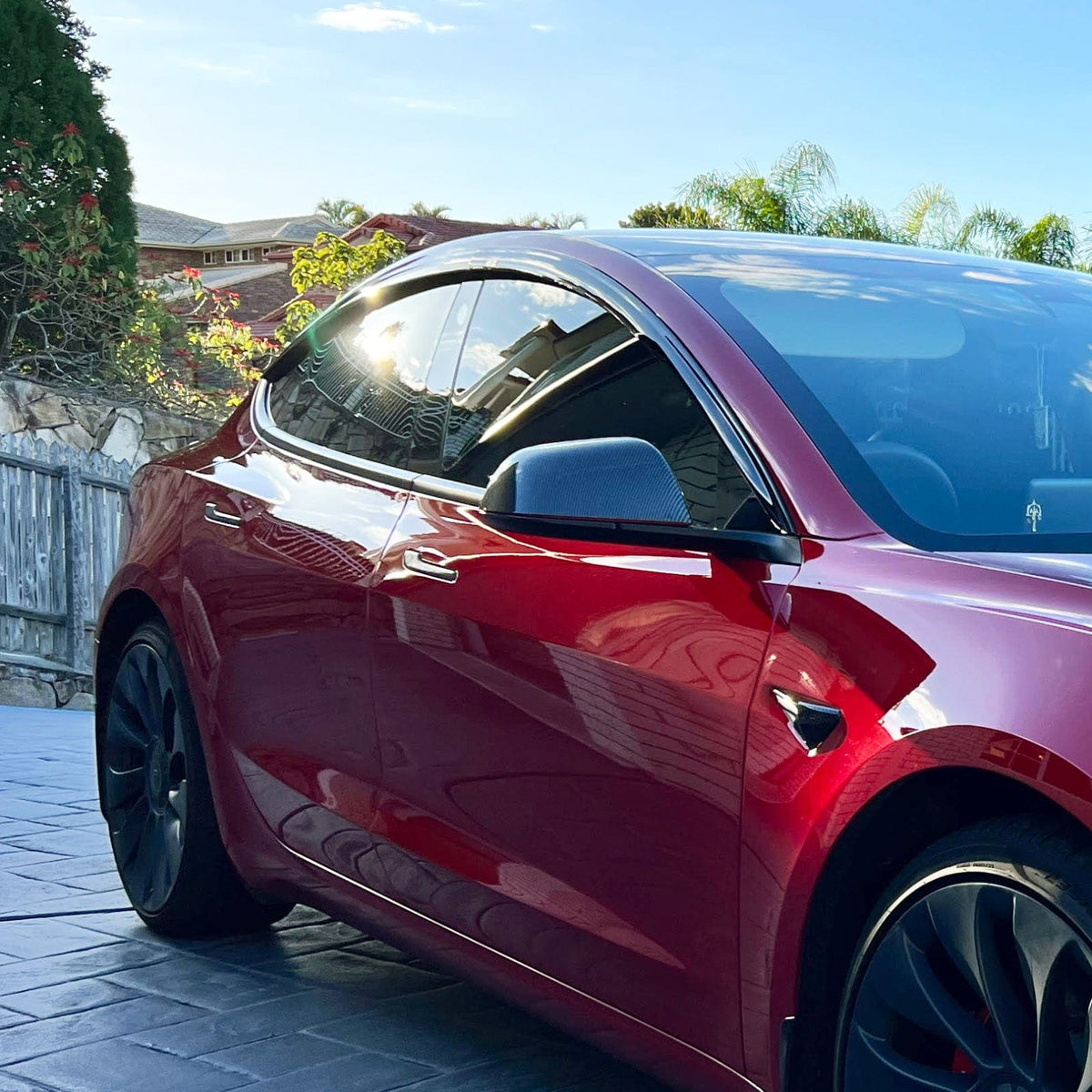 HIC weather shield installed on a red Tesla Model 3, close-up of front door window